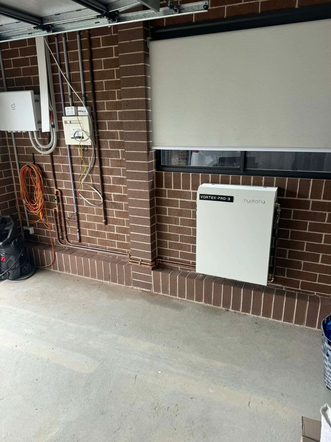 Whole home filter installed in a garage beside the meter box
